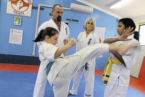 FIGHTING FIT: John and Hollie Rule watch over Carla Vonnida, 9, and Janvi Beri, 12, as they prepare for this weekend’s Power Karate Titles at the Griffith PCYC. Picture: Anthony Stipo