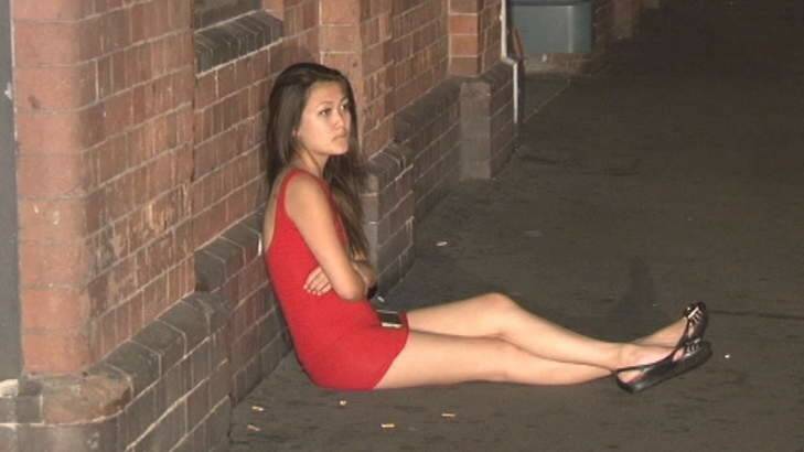 A woman sits near the scene of the assault that occurred in Haymarket last night, before being driven away by police. Photo: Ten Eyewitness News Photo: Ten Eyewitness News