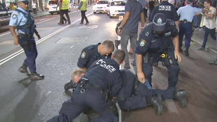 Police detain an alleged brawler on George Street outside the Ivy nightclub. Photo:  ABC News
