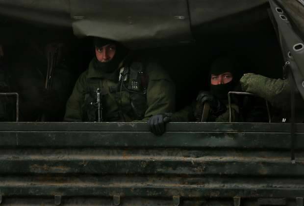 Russian troops peer out the back of Russian military trucks as they are transported in a convoy heading north of  Simferopol, Crimea. Photo: Kate Geraghty
