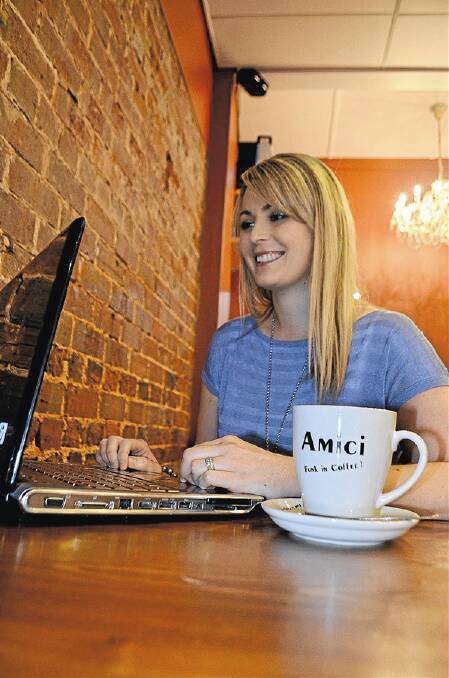WEB-SAVVY: Amanda Quarisa works while she enjoys a coffee in Banna Avenue yesterday. Griffith’s entire main street could become Wi-Fi active under a proposal by the local business chamber.