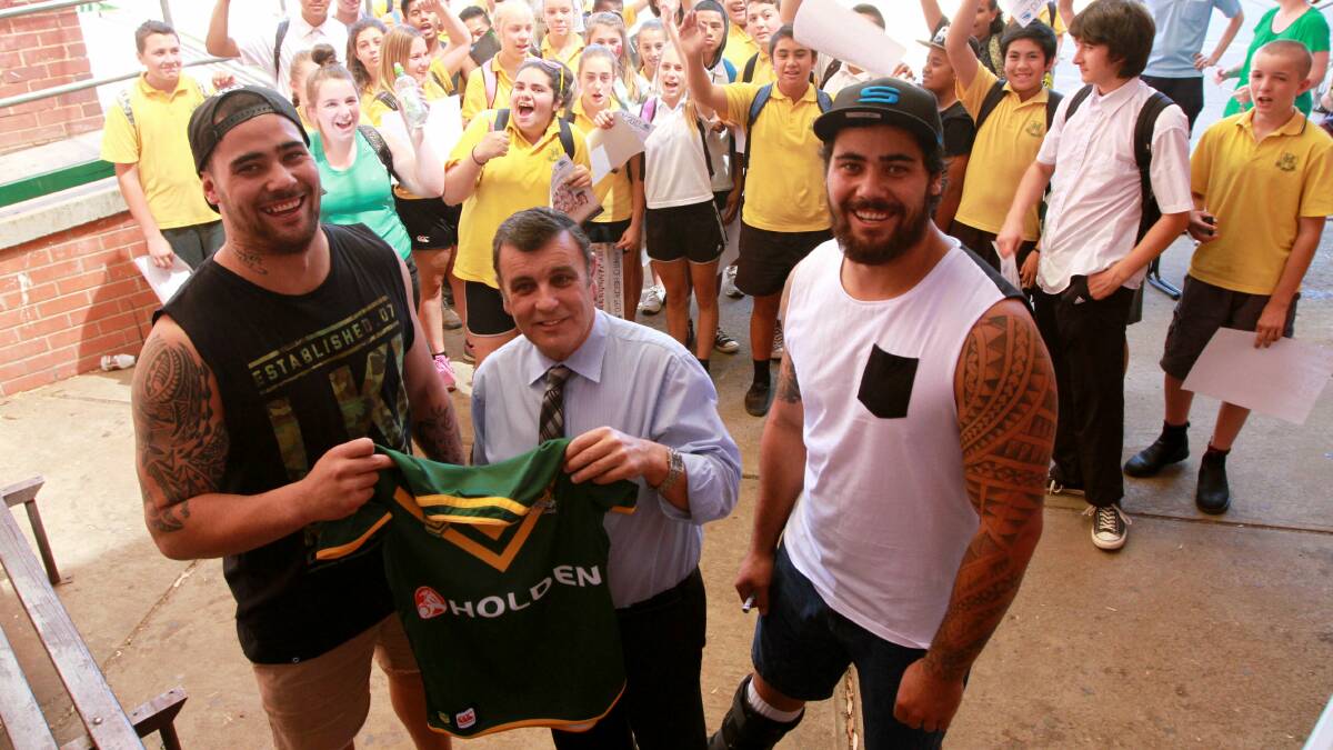 MERRY CHRISTMAS: Andrew Fifita and his twin brother David present Griffith High principal Charlie Cochrane with a signed Kangaroos jersey. Picture: Anthony Stipo