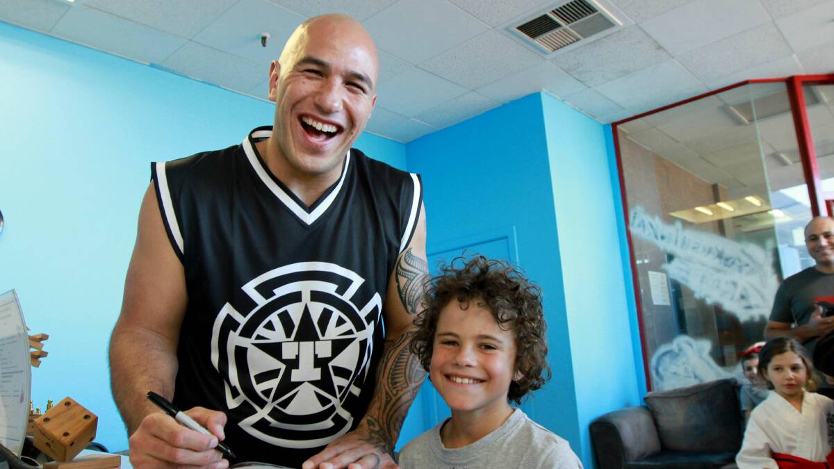 SPREADING THE TRUTH: UFC star Brandon Vera signs an autograph for Taine Moraschi, 9, before his seminar at RMA & Total Fitness.