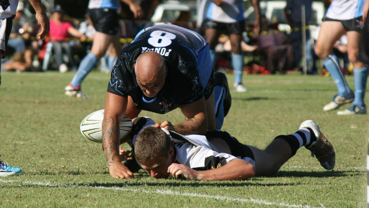 Quentin Pongia flattens Hay's Simon Parr during the Pie in the Sky exhibition match in Hay in 2011. Pongia will pull on the black and white for the Magpies this year.