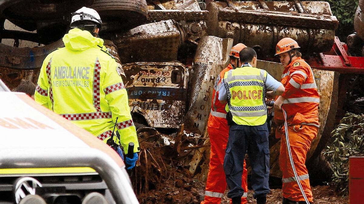 TRAGEDY: Emergency service crews assess the wreckage at a fatal crash yesterday morning, which claimed the life of the driver. Photo: Anthony Stipo