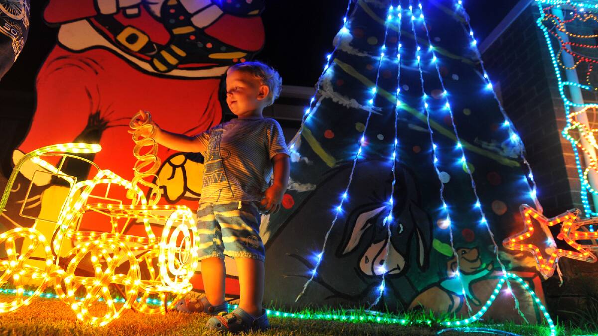Caleb Bean, 17 months, plays with the Christmas lights display in Loth Street, Ashmont.
