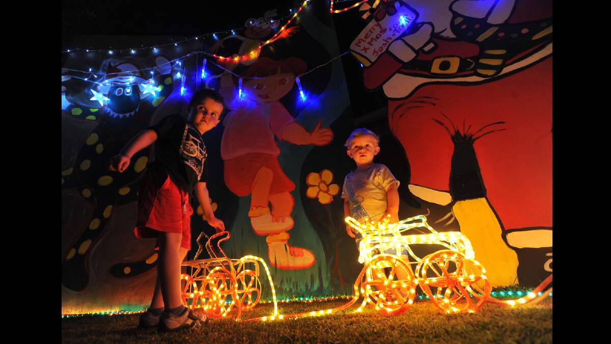 Declan Roberts, 4, and Caleb Bean, 17 months, explore the Christmas lights display in Loth Street, Ashmont.