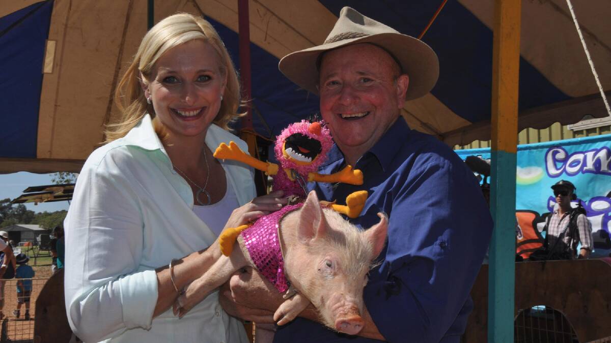 Jo Griggs and Dr Harry from Better Homes and Gardens with one of the entrants at the Comedy Pig Races at the 2013 Griffith Show. 