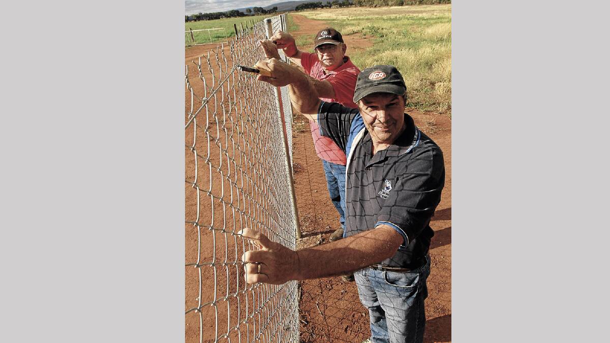 WIRED: George Santalucia and Louie Forner with the new fence they built at the Yenda cemetery.