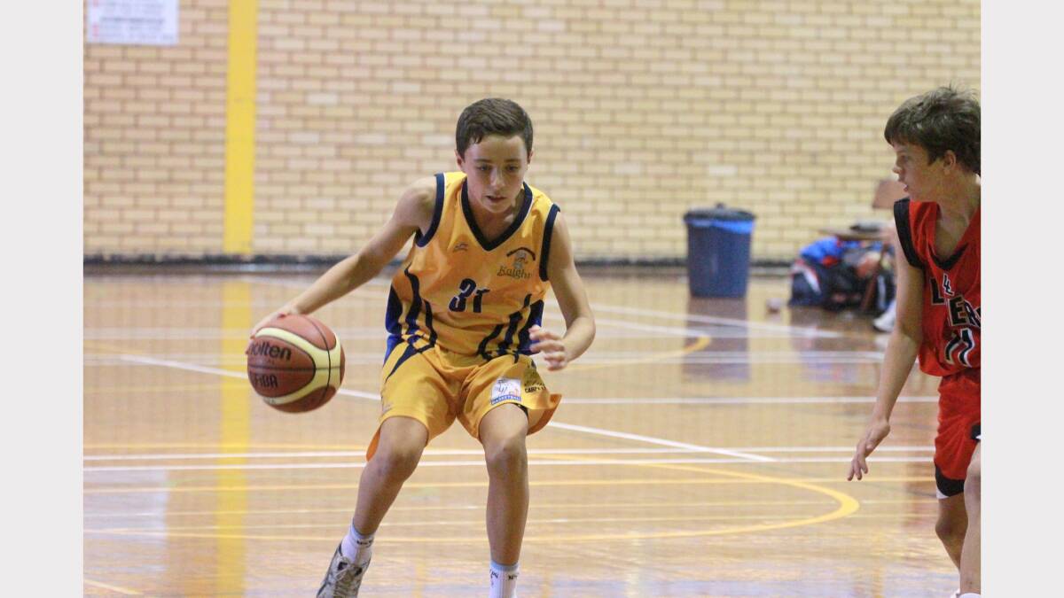 Narrandera Knights' basketballer Isaac Williams dribbles against a Lithgow Lazers opponent in the junior state basketball competition. Picture: Anthony Stipo