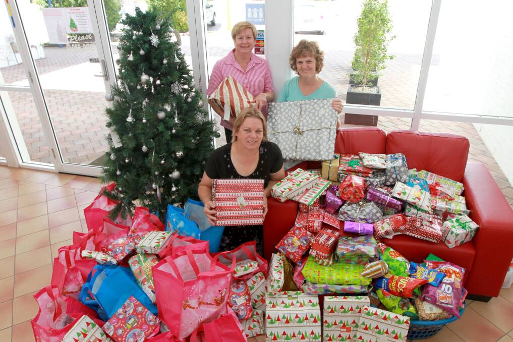 Wendy Power and Susan Bridgman from the Griffith Women's Refuge, thank The Area News manager Lyn Urquhart for more than 100 gifts donated to the paper's giving tree. Picture: Anthony Stipo