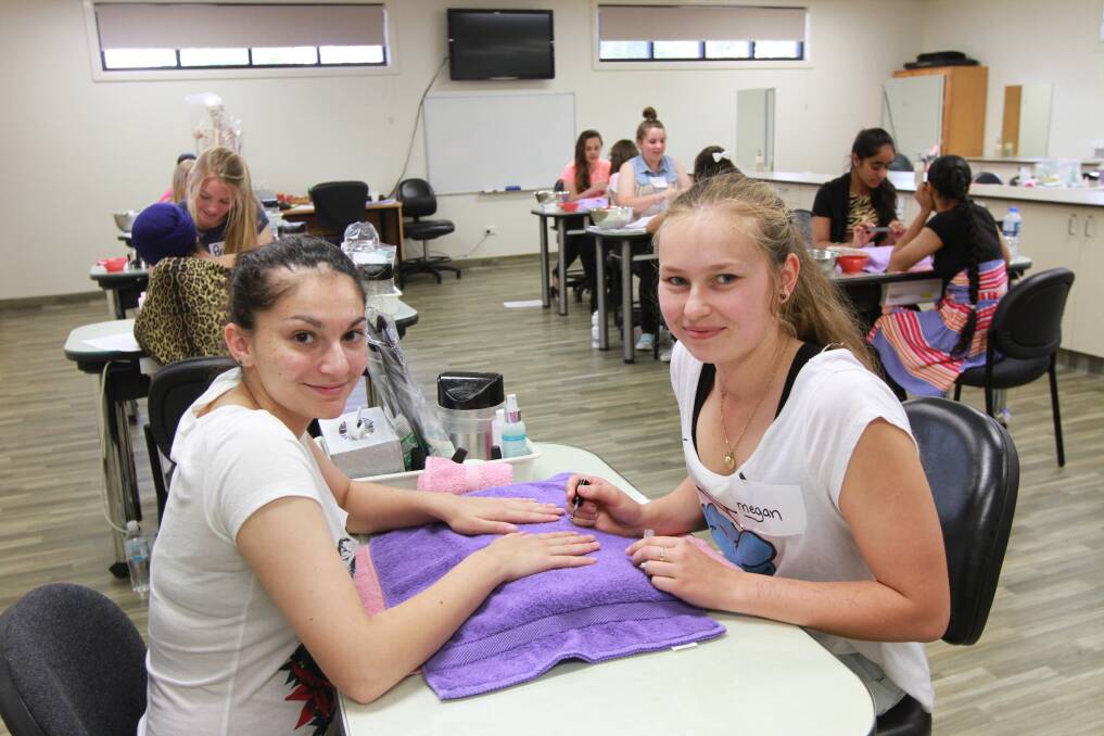 Griffith High’s Caitlin Gill has her nails done by Marian Catholic College student Megan Rossiter during A Taste of TAFE last week. Picture: Anthony Stipo