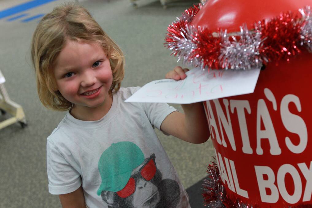 Finley Wallace, 4, posts his letter off to Santa Claus using the box at Griffith City Library. Nice little boys and girls in Griffith have until Friday, December 13 to get them in. Picture: Anthony Stipo