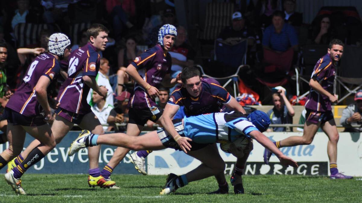 TLU's Sam Fensom is tackled by the Bidgee Hurricanes defence in the Group 20 grand final. The Sharks went on to win their first grand final in almost 40 years. Picture: Anthony Stipo