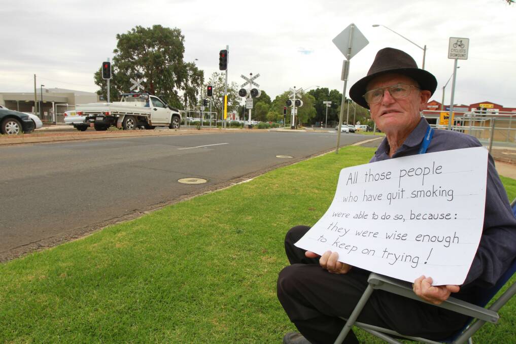 Arthur Johnson uses his sign to try and convince locals to quit smoking. Picture: Anthony Stipo