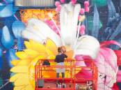 FLORAL: Artist Mandy Schone-Salter painting her mural in 2021 of wildflowers endemic to NSW. PHOTO: Supplied 