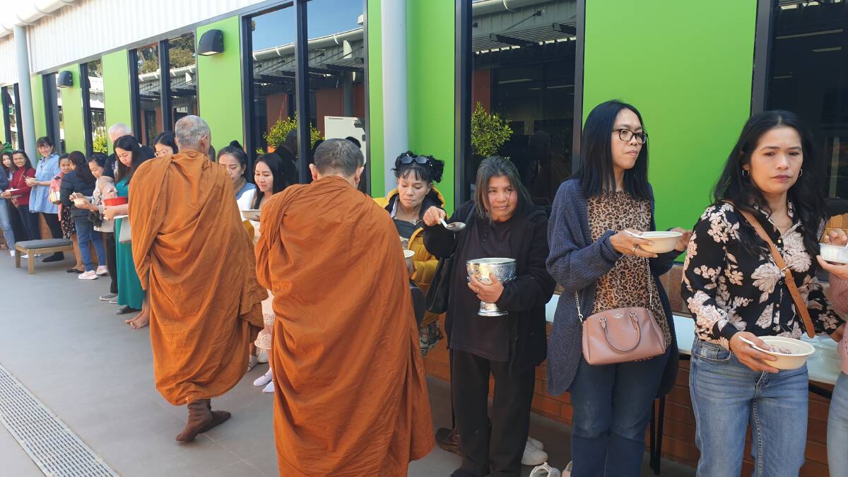 The attendees offering alms to the monks. Photo by Cai Holroyd