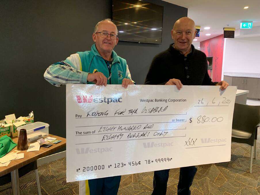 KACHING: Mark Jaffrey from the Griffith Exies Bowling Club presents the cheque to Tony Short from the Griffith and Leeton Riding for the Disabled Association. PHOTO: Contributed