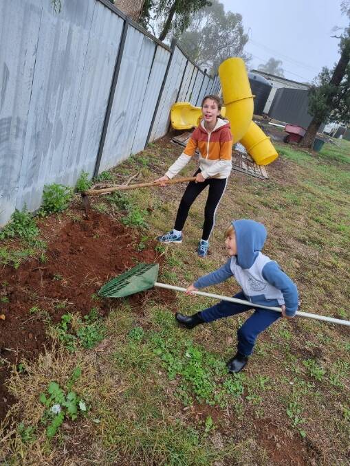 RAKE UP FOR LOST TIME: Sofia and Rafael Sharpe have been working hard over the school holidays, assisting with the garden development. PHOTO: Contributed