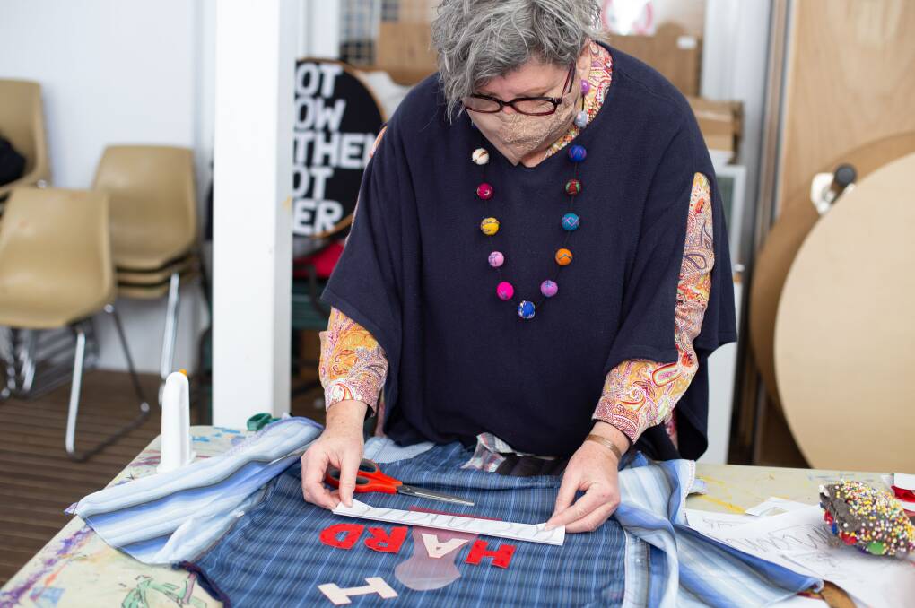 METICULOUS: Narrandera artist Lindee Russell designing an apron. The end product should read 'I am woman' over the word 'Hard' and include a padlock, symbolising women being locked out of male dominated industries. PHOTO: Contributed