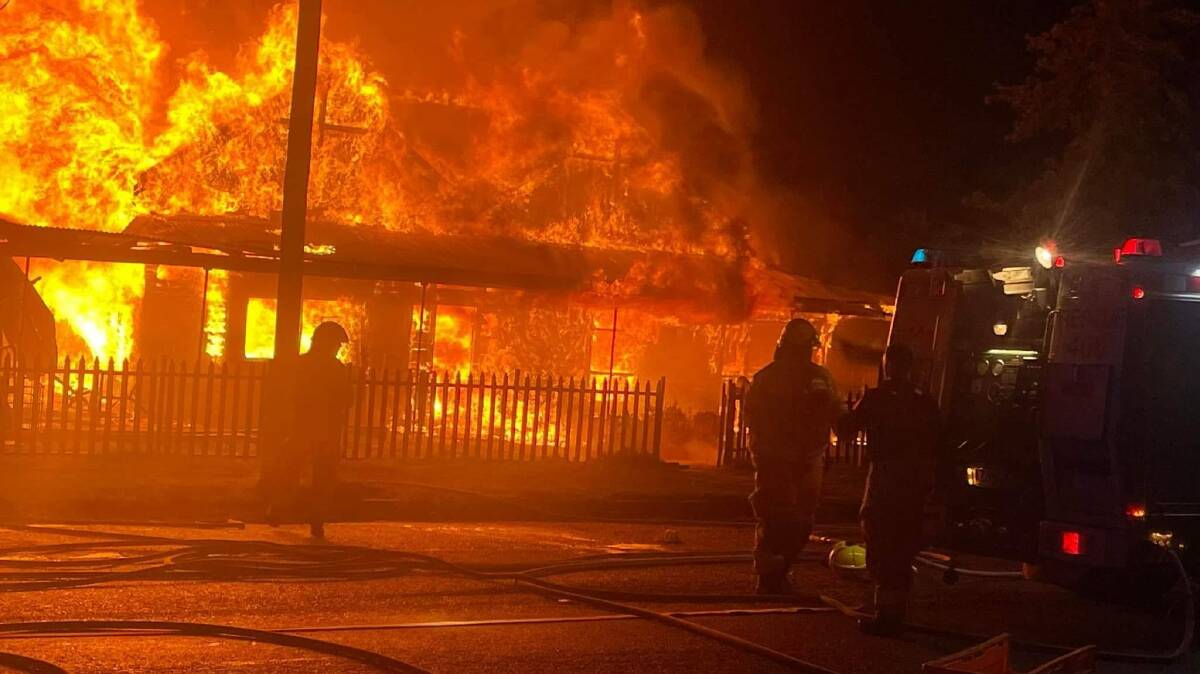 ABLAZE: The house was completely enveloped in flame, with firefighters working hard to protect the buildings to either side. PHOTO: Fire and Rescue NSW