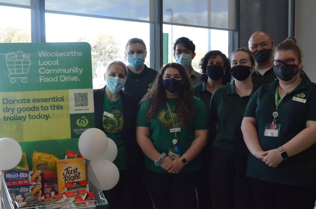 LOCAL INITIATIVE: Team members at Woolworths Griffith North pose alongside the Community Food Drive Trolley. PHOTO: Lizzie Gracie