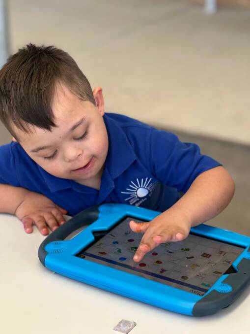 Jayden Simpson in Kindergarten using his iPad for interactive learning. 