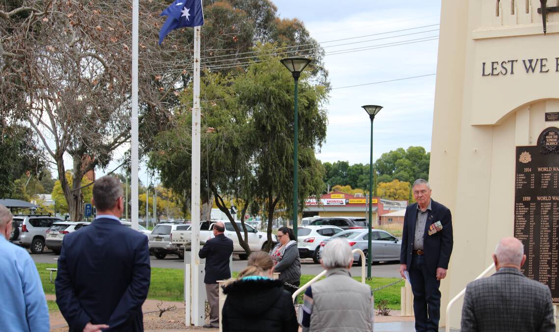 Attendees pause for The Last Post as the Australian flag is lowered. PHOTO: Vincent Dwyer