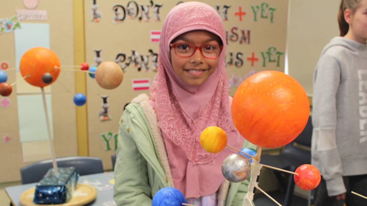 BEST AND BRIGHTEST: Grade 5 student Nawshin Anjum with her finished project showing the eight planets orbiting the sun. PHOTO: Vincent Dwyer