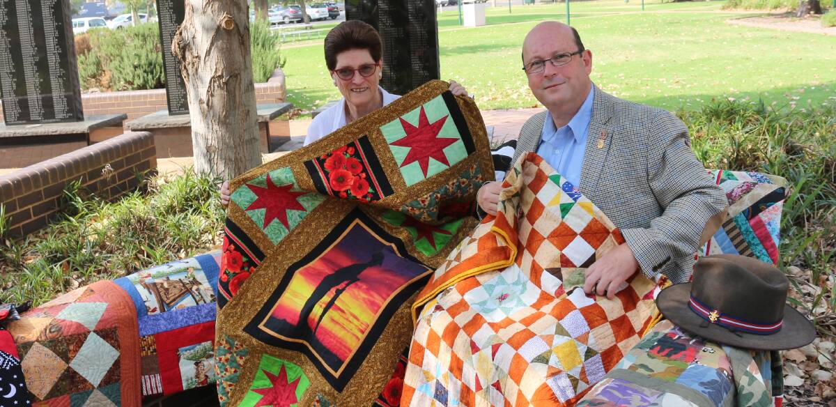 COSY: Murrumbidgee Country Quilters president Gaynor Clements keeps warm with ex-serviceman Captain Jon Belmonte at Memorial Park. PHOTO: Kenji Sato