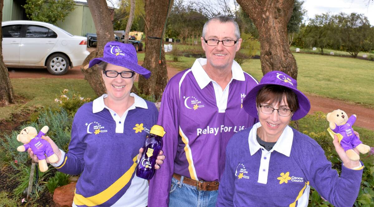 PRETTY IN PURPLE: Griffith Relay for Life committee members Tammy Hirst, Grant Hearn, and Denise Hearn get ready for Purple Day, which comes in the lead up to their tenth relay on October 12 and October 13. PHOTO: Kenji Sato