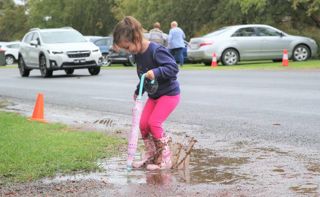 3-year-old Macie Puntoriero splashes around in a puddle on Monday