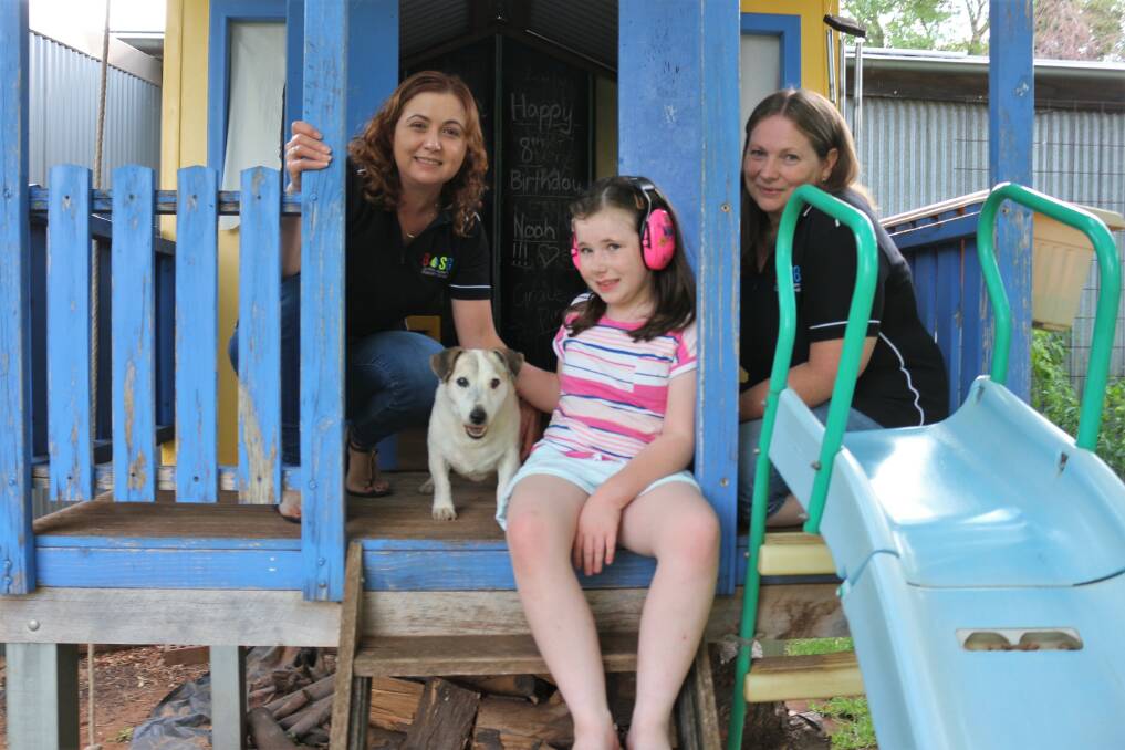 TREE HOUSE BUDS: Griffith Autism Support Group's Dene Beltrame, Merlin the dog, Zoe Frizell, and Alison Frizell share a moment inside a wooden treehouse built in the backyard. PHOTO: KENJI SATO