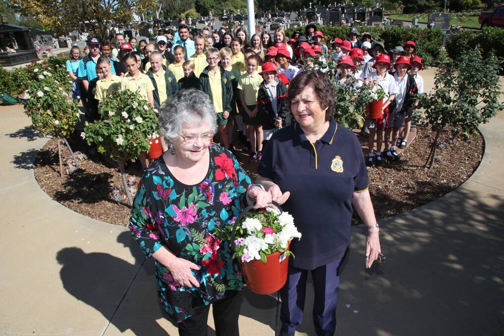 LITTLE HELPERS: Margaret Tucker and Ffiona Beverly are joined by primary and high school students from all around Griffith on Thursday. Together they placed flowers on the graves of ex-servicemen and women. PHOTO: Anthony Stipo