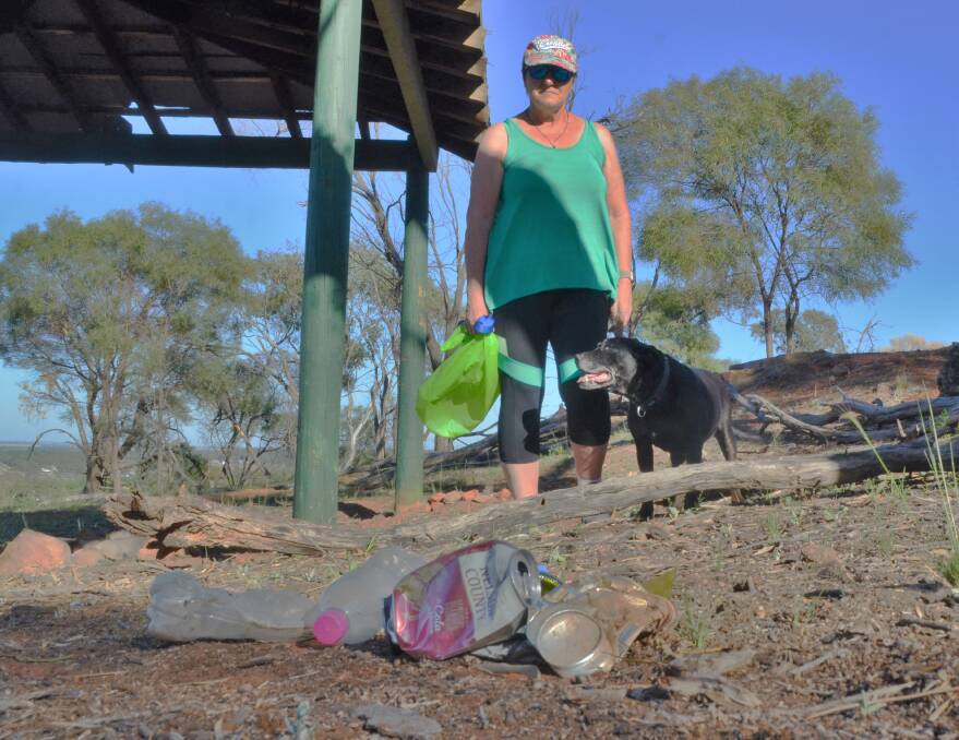 FURIOUS: Sue Fordham and Juno the dog next to a pile of rubbish on Scenic Hill. Picture: Kenji Sato