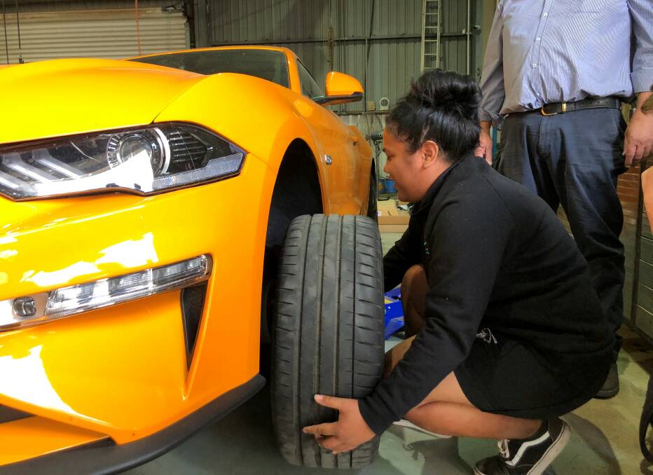 HANDS ON: Murrumbidgee Regional High School student Faaoso Afuvai learns the finer points of changing a car tyre. PHOTO: Contributed
