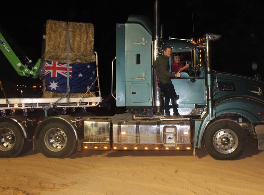 READY TO ROLL: Sunrise weather man Sam Mac jumps onto the side of the first truck off the rank in the convoy. Picture: Hannah Higgins
