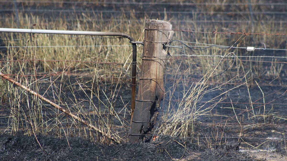 A fence post continues to smoulder in the aftermath of the Blackford fire. PHOTO: Elisabeth Champion 