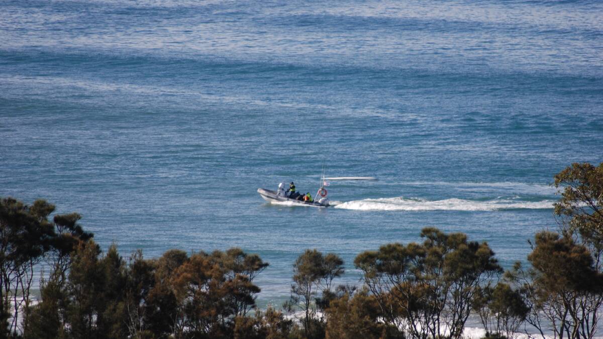 A Marine Rescue boat picks up the unconscious man and lifesavers who were performing CPR at Surf Beach on Monday, July 5. Picture: John Hanscombe. 