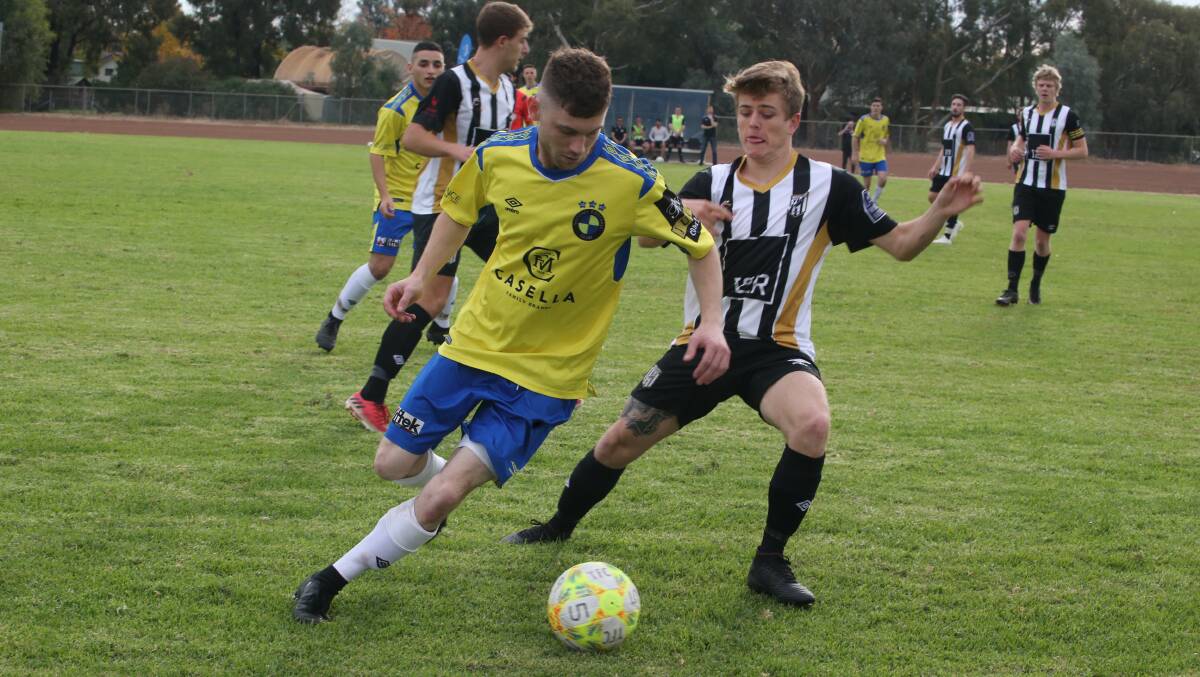 ENTRY BID: Yoogali FC's Domenic Perre tries to evade West Griffith defender Brodie Seidel during a match last year. 