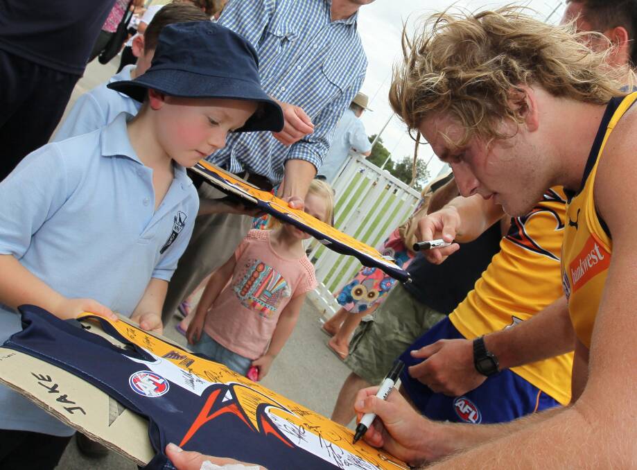 SPECIAL MOMENT: Wagga six-year-old Jake Taylor gets an autograph from West Coast footballer Tom Lamb at the club's open training session at Robertson Oval on Friday. Picture: Les Smith