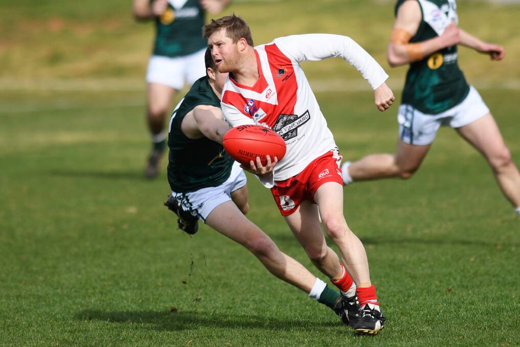 Kris Duncan gets a handball away for the Swans in the loss to Coolamon last Saturday.