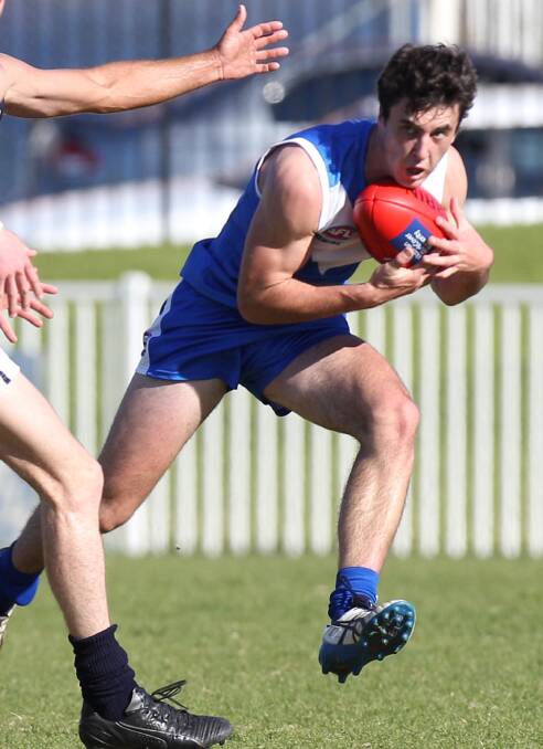 DETERMINED: Farrer player Lachie Flagg tries to dodge a tackle attempt.