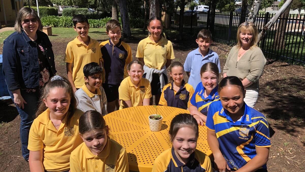 COLLABORATION: Karen Woolnough (far left) from Hanwood P&C and Principal of Hanwood PS Monica St Baker (far right) with Year 6 students and SRC representatives in the garden space that will receive the two new outdoor chairs.