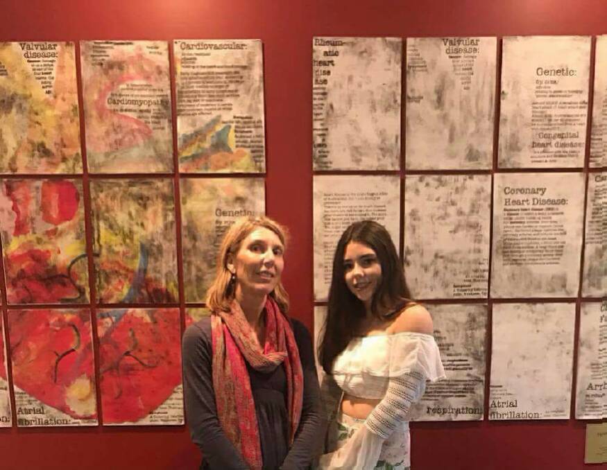 Janelle and Emma Toole infront of Emma's artwork in the Heart Foundation office.