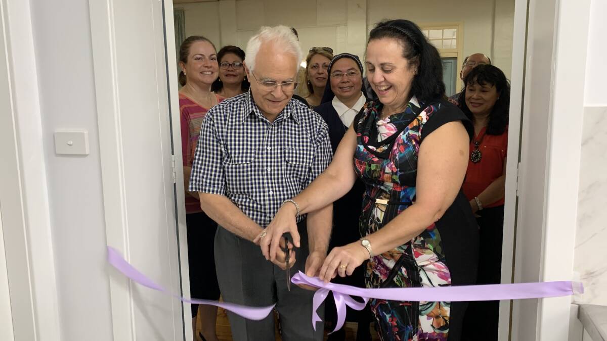 SHOWING HEART: Builder Angelo Barone and secretary Anna Rosetto cutting the ribbon to officially open the new hall kitchen. PHOTO: Jacinta Dickins