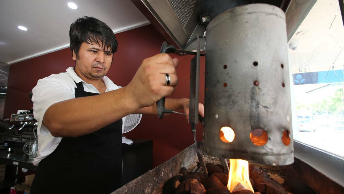 SECOND TO NAAN: Ahmad Alizada revs up the fire to start preparing the kebab meat for the day. PHOTO: Anthony Stipo