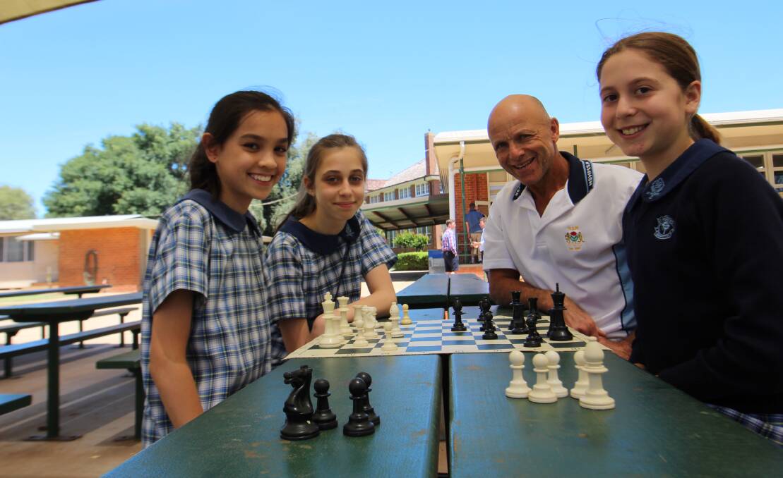 BATTLE: Shania Shipton, Chloe Zamin and Anika Smith with 'chess master' Peter Moraschi practicing strategies ahead of the state championships. PHOTO: Jacinta Dickins