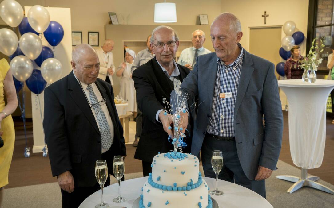 CELEBRATE: Former committee president Joe Catanzariti, Fr Nevio Capra and board chairman Professor Leroy Certoma cut the 30th anniversary cake.