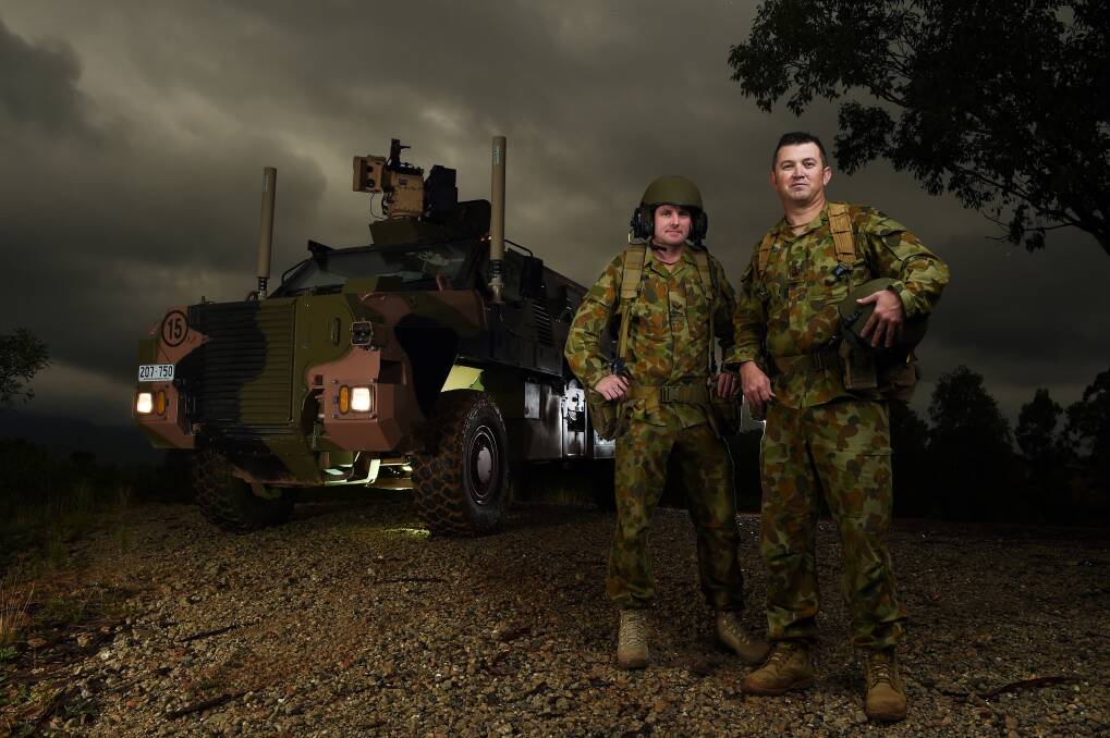 HEAVY MUSCLE: Australian Army soldiers Warrant Officer Class 2 Cameron McKenzie and Corporal Ian Wilson with the "bushmaster" tank at the Army Logistic Training Centre's barracks at Bandiana. Picture: MARK JESSER